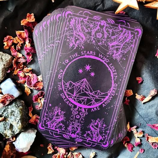 Cartes de tarot violettes avec motifs ésotériques et inscriptions mystiques.